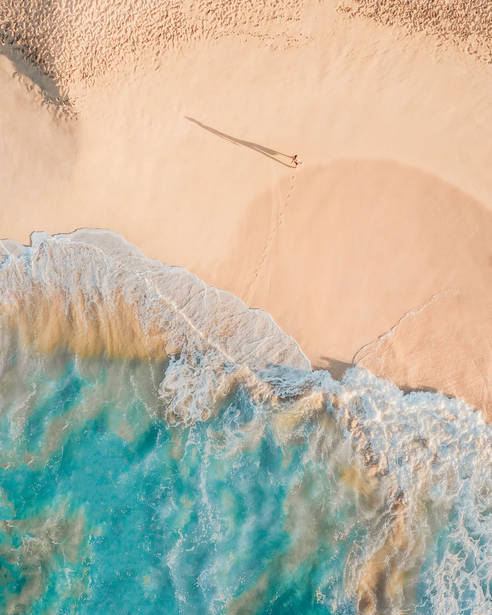 Turquoise surf rolling onto a bright Bahamian beach.